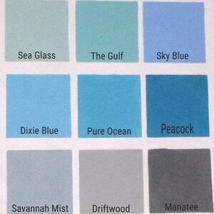 Nine paint swatches with names below each swatch. The swatches are in three rows of three. The top row is light green, light blue, and sky blue. The middle row is light blue, blue, and teal. The bottom row is light gray, gray, and dark gray. The names are 'Sea Glass', 'The Gulf', 'Sky Blue', 'Dixie Blue', 'Pure Ocean', 'Peacock', 'Savannah Mist', 'Driftwood', and 'Manatee'.