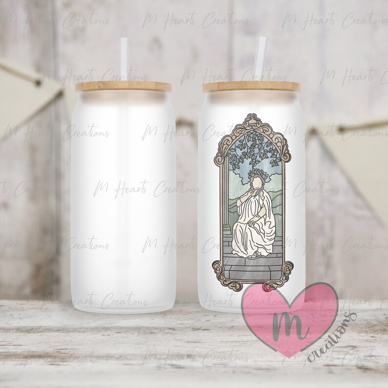 May include: Two white stainless steel tumblers with a wood lid. One tumbler has a graphic of a woman in a crown sitting on a throne with a leafy background. The other tumbler is blank. Both tumblers have a straw.