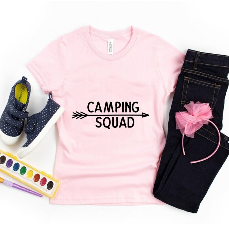 May include: Pink t-shirt with black text that reads "Camping Squad" with an arrow pointing to the right.