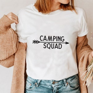 May include: White t-shirt with black text that reads "Camping Squad" and a black arrow pointing to the right.
