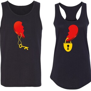 May include: Two black tank tops with a red heart design. One tank top has a key hanging from the heart, and the other tank top has a padlock hanging from the heart.