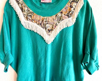 Camisa de punto corta estilo años 80, estilo western, con flecos, canesú y apliques, ideal para festivales y eventos.