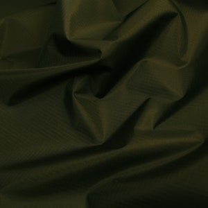 May include: A close-up of a dark green fabric with a subtle textured pattern. The fabric is wrinkled and folded, creating a soft, drapey look.