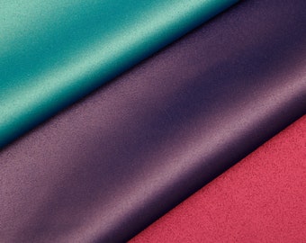 May include: Close-up of three fabric swatches. The top swatch is teal blue, the middle swatch is dark purple, and the bottom swatch is pink.