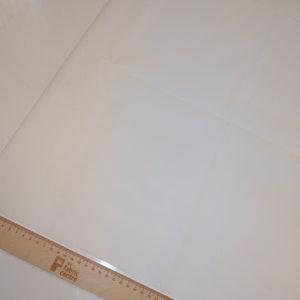 May include: A white fabric swatch with a wooden ruler labeled "The Fabric Centre" in the bottom left corner.