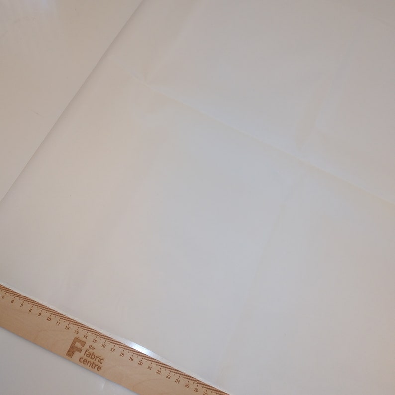 May include: A white fabric swatch with a wooden ruler labeled "The Fabric Centre" in the bottom left corner.