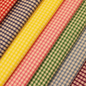 May include: A collection of eight fabric swatches in various colours and gingham patterns. The swatches include red, blue, yellow, pink, green, light blue, purple, and brown.