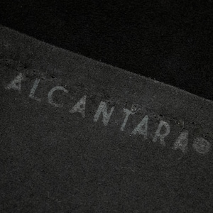 May include: Close-up of black fabric with the word "ALCANTARA" embossed in white.
