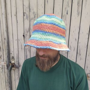May include: A crocheted bucket hat with stripes of blue, green, pink, and orange.