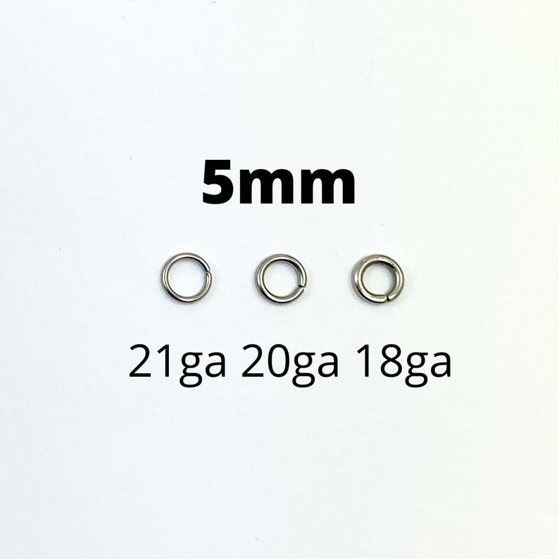 May include: Three silver-colored jump rings, each 5mm in diameter, are displayed against a white background. The text "5mm" is above the rings, and "21ga 20ga 18ga" is below. These rings are likely used for jewelry making or crafts.