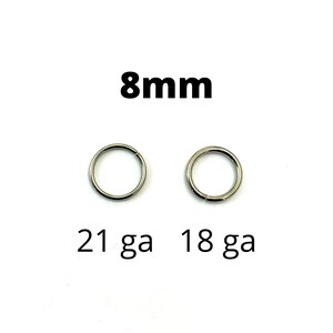 May include: Two silver-colored, circular rings with a diameter of 8mm are displayed against a white background. The text "8mm" is above the rings. Below the rings, the text reads "21 ga 18 ga".
