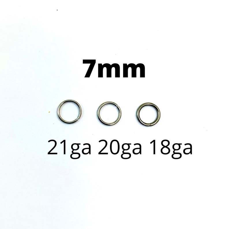 May include: Three silver-colored, circular rings with varying gauges (21ga, 20ga, 18ga) are displayed. The text "7mm" is above the rings, indicating their size. The rings are set against a plain white background.