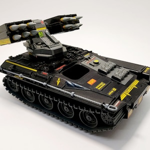 Pode incluir: Tanque de brinquedo preto com um lançador de mísseis no topo. O tanque tem um esquema de cores preto e amarelo e apresenta um design detalhado. O lançador de mísseis tem vários mísseis presos a ele.