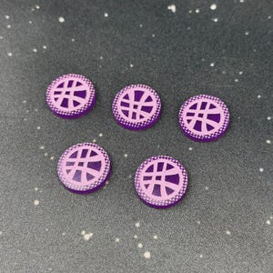 以下が含まれることがあります： 薄紫のデザインと点線ボーダーが付いた、紫色の円形オブジェクトが5つ。 デザインは様式化されたシンボルに似ています。 オブジェクトは、白い斑点のある濃い灰色の表面に配置されています。