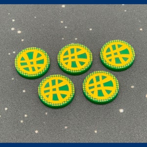 May include: Five green and yellow circular tokens with a yellow symbol in the center. The symbol is a stylized circle with lines radiating from the center.