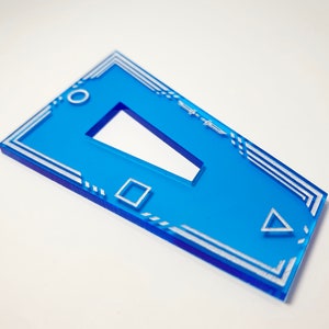 K&ouml;nnte beinhalten: Ein blauer Acryl-Schl&uuml;sselanh&auml;nger mit einem wei&szlig;en geometrischen Design. Das Design beinhaltet ein Quadrat, ein Dreieck und ein Rechteck. Der Schl&uuml;sselanh&auml;nger hat oben ein Loch zum Anbringen an einem Schl&uuml;sselring.