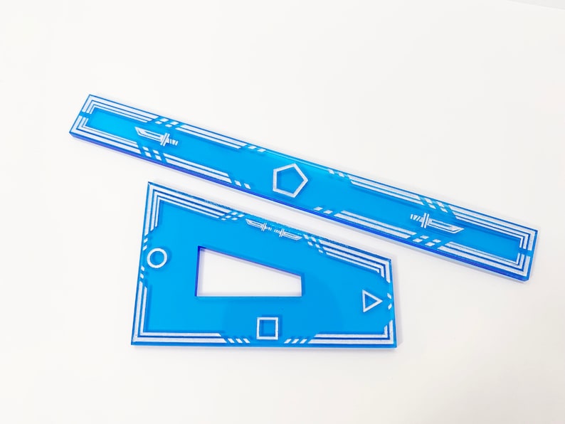K&ouml;nnte beinhalten: Zwei blaue Acryl-Lineale mit wei&szlig;en geometrischen Mustern. Das gr&ouml;&szlig;ere Lineal hat eine f&uuml;nfeckige Form in der Mitte und das kleinere Lineal hat einen Kreis, ein Quadrat und ein Dreieck.