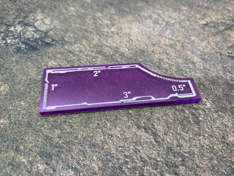 Peut inclure: Une r&egrave;gle en plastique violette avec des marques blanches. La r&egrave;gle mesure 7,6 cm de long et comporte des marques pour 2,5 cm, 5 cm, 1,3 cm et 7,6 cm.