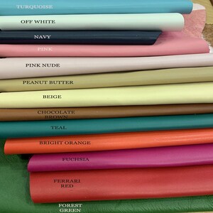 May include: A stack of 13 leather swatches in various colors, including turquoise, off white, navy, pink, pink nude, peanut butter, beige, chocolate brown, teal, bright orange, fuchsia, Ferrari red, and forest green.
