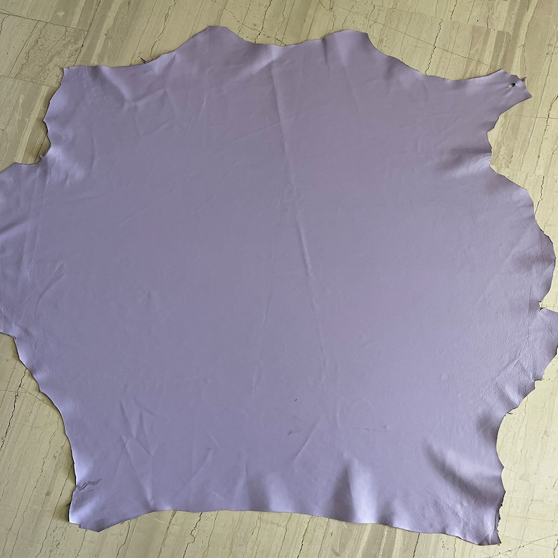 May include: A large piece of light purple leather. The leather is smooth and has a slight sheen.
