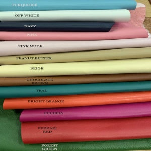 Pode incluir: Uma pilha de amostras de couro coloridas em v&aacute;rias tonalidades, incluindo turquesa, branco sujo, azul marinho, rosa, rosa nude, manteiga de amendoim, bege, castanho chocolate, verde-azulado, laranja brilhante, f&uacute;csia, vermelho Ferrari e verde floresta. Cada amostra &eacute; rotulada com o seu nome de cor.