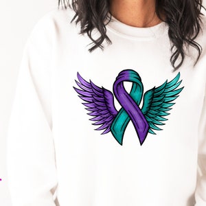 Puede incluir: Sudadera blanca con un diseño de cinta turquesa y morada con alas de ángel. El estampado gráfico incluye el texto "DEBBIE DOES DESIGN" y "HIGH-RES PRINT FILES 300 DPI PNG".