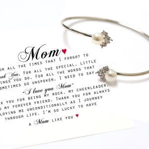 May include: A silver bangle bracelet with two pearl charms and a card with the text "Mom" and a message of appreciation for a mother. The card reads "For all the times that I forgot to thank you, for all the special, little things you do, for all the words that sometimes go unspoken, I need to say "I love you Mom." Thank you for being my rock, my cheerleader, and my forever friend. Thank you for always loving me unconditionally as I journey through life. I'm so lucky to have a Mom like you."