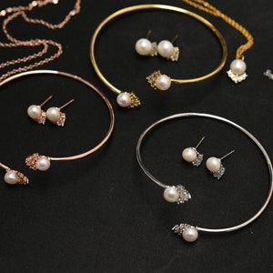 May include: Three sets of jewelry featuring pearl and crystal accents. Each set includes a necklace, a bracelet, and a pair of earrings.