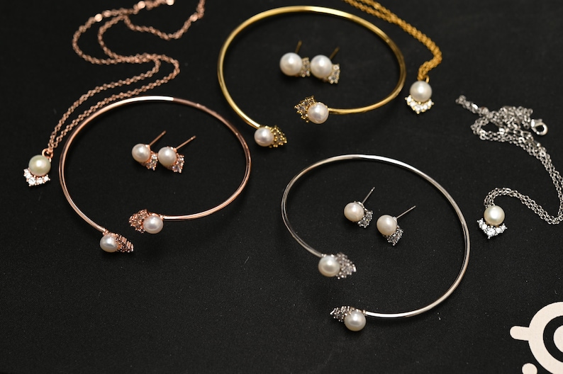 May include: Three sets of jewelry featuring pearl and crystal accents. Each set includes a necklace, a bracelet, and a pair of earrings.