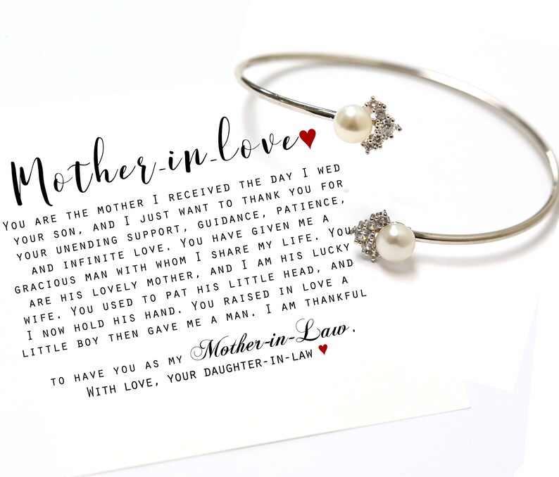 May include: A white card with a silver bracelet and two pearls. The card has a handwritten message that reads "Mother-in-love You are the mother I received the day I wed your son, and I just want to thank you for your unending support, guidance, patience, and infinite love. You have given me a gracious man with whom I share my life. You are his lovely mother, and I am his lucky wife. You used to pat his little head, and I now hold his hand. You raised in love a little boy then gave me a man. I am thankful to have you as my Mother-in-Law. With love, your daughter-in-law."