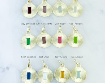 May include: A collection of twelve gold-colored pendant charms, each featuring a different gemstone and corresponding month. The gemstones include garnet, amethyst, aqua, diamond, emerald, alexandrite, ruby, peridot, sapphire, opal, citrine, and zircon.