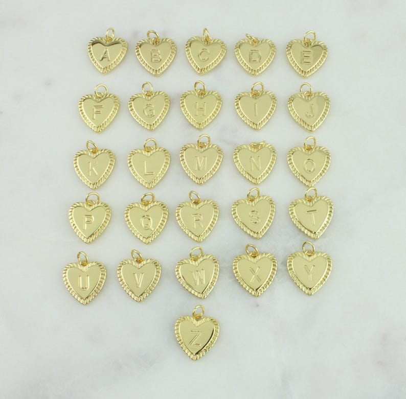 May include: A set of 26 gold heart-shaped charms, each featuring a different letter of the alphabet. The charms are ideal for adding a personalised touch to jewellery.
