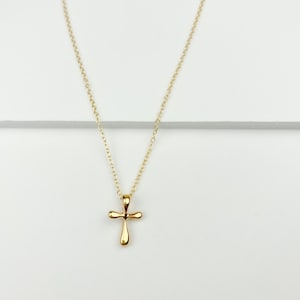 May include: A gold chain necklace with a small, simple gold cross pendant.
