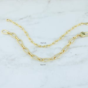 May include: Two gold-colored chain links, one with oval links and the other with cap links, are displayed on a white marble surface. The oval link chain is above the cap link chain. The text "Oval Link" and "Cap Link" are visible.