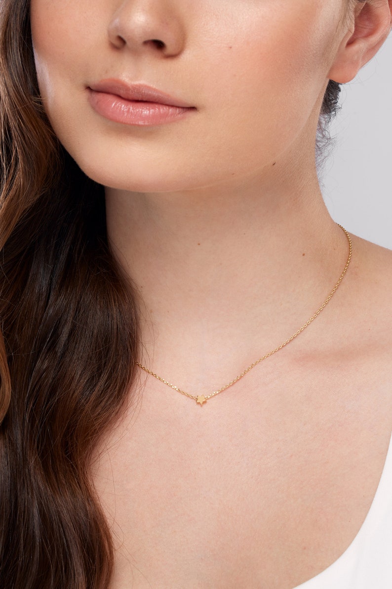 Peut inclure: Un collier d&eacute;licat en cha&icirc;ne dor&eacute;e avec un petit pendentif en forme d'&eacute;toile.