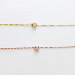 Peut inclure: Deux cha&icirc;nes d&eacute;licates en or avec un petit pendentif en forme d'&eacute;toile. La cha&icirc;ne du haut est en or et la cha&icirc;ne du bas est en or rose.