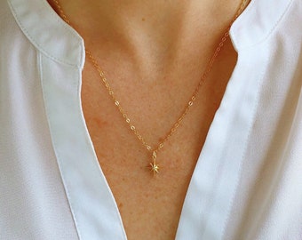 May include: A gold chain necklace with a small, star-shaped pendant.