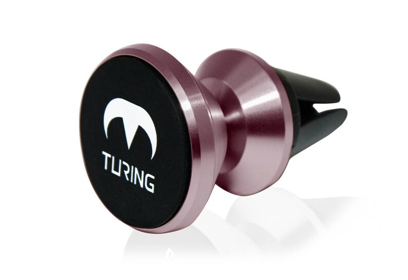 Pu&ograve; includere: Un supporto per telefono per la ventilazione dell'auto in oro rosa con un disco magnetico nero. Il disco ha un logo bianco che dice "TURING" e un design stilizzato di cima di montagna bianca.