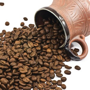 K&ouml;nnte beinhalten: Eine braune Keramikkrug, umgesto&szlig;en, wobei ger&ouml;stete Kaffeebohnen herausfallen. Die Bohnen haben eine satte, dunkelbraune Farbe, mit einigen um den Krug herum verstreut. Der Krug hat eine strukturierte Oberfl&auml;che und einen Henkel.