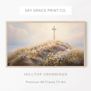 Op de afbeelding: Een ingelijst schilderij met een wit kruis op een heuveltop, omringd door een veld met witte bloemen. De lucht is zachtblauw met wolken. Het schilderij is getiteld "Hilltop Crossings" en wordt beschreven als "Premium 4K Frame TV Art".