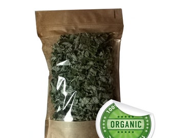 Puede incluir: Una bolsa transparente llena de hierbas verdes secas, sellada con una parte superior de papel marrón. Una pegatina blanca con la palabra "ORGANIC" en verde está en el lado derecho de la bolsa. La pegatina también tiene las palabras "100% ORGANIC" alrededor del borde.