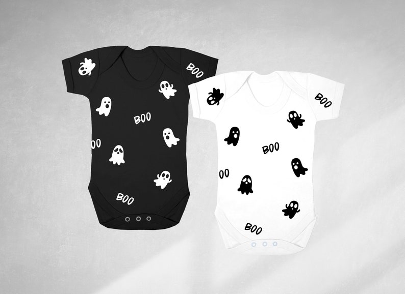 May include: Two baby onesies, one black and one white, with a ghost and "BOO" pattern.
