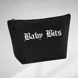 May include: Black pouch with a zip closure, featuring the words "Baby Bits" in a gothic font. The bag is made of a durable material. The zip is metallic.
