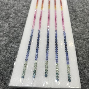 Puede incluir: Cinco hileras de cuentas de piedras preciosas, cada hilera es un degradado de cuentas verdes, azules, rosas y naranjas.