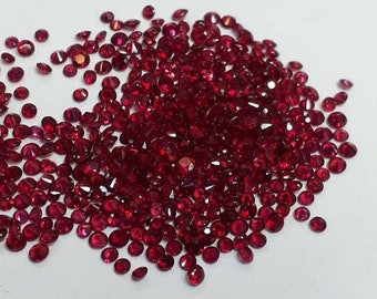Puede incluir: Un montón de piedras preciosas de rubí rojo sueltas sobre un fondo blanco.