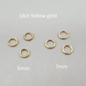 Könnte beinhalten: Sechs 18ct Gelbgold-Sprungringe mit einem Durchmesser von 6 mm und 7 mm werden vor einem grauen Hintergrund gezeigt. Der Text "18ct Yellow gold" befindet sich über den Ringen. Die Größen sind unten angegeben.