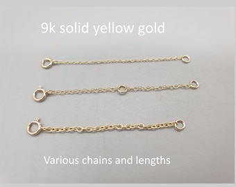 May include: Three 9k solid yellow gold extender chains of varying link sizes and lengths, each featuring a circular spring ring clasp at one end and a small jump ring at the other. The text 9k solid yellow gold and Various chains and lengths is visible.
