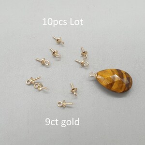 May include: A 10pcs lot of 9ct gold jewellery findings including small screw-eye bails and one faceted teardrop-shaped tiger's eye gemstone pendant. The text 10pcs Lot and 9ct gold is visible on the image, indicating the quantity and material.