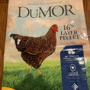 May include: A bag of Dumor 16% Layer Pellet poultry feed featuring a brown and black hen standing in a green field. The packaging includes the text Balanced Poultry Nutrition, Purina, 100% Complete Formula For All Laying Hens, Calcium Fortified, and Prebiotics & Probiotics.