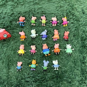 Puede incluir: Una colección de diecisiete figuras de plástico que representan varios personajes de cerditos de dibujos animados con trajes coloridos, incluyendo un coche de juguete rojo. Las figuras están dispuestas en cuadrícula, mostrando diversas poses y colores.